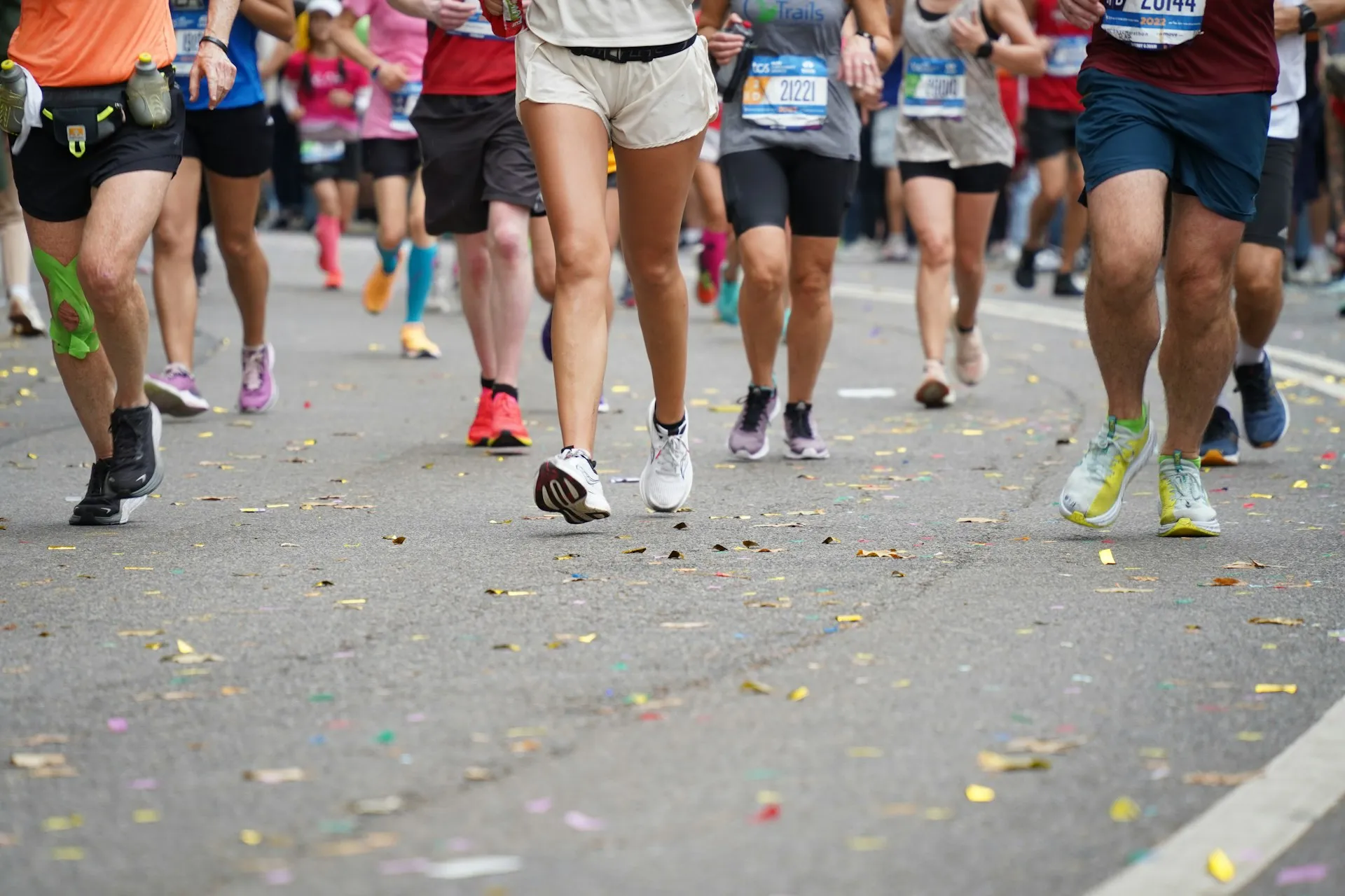 Runners on a confetti-covered street during a marathon